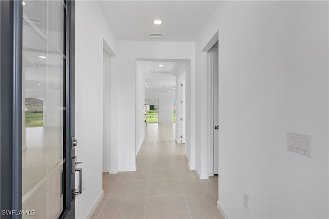 corridor featuring light tile patterned flooring and beverage cooler