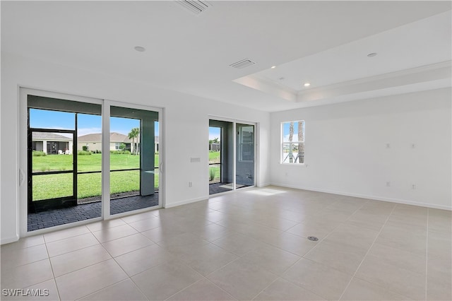 unfurnished room featuring a raised ceiling, light tile patterned floors, and crown molding