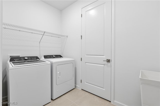 laundry room with washing machine and dryer and light tile patterned floors