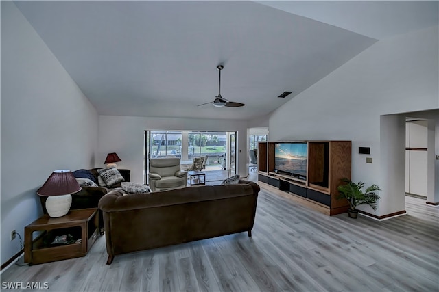 living room featuring lofted ceiling, ceiling fan, and light hardwood / wood-style flooring