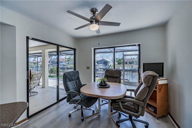 home office featuring ceiling fan, light wood-type flooring, and a wealth of natural light