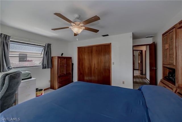 bedroom with a closet, tile floors, and ceiling fan