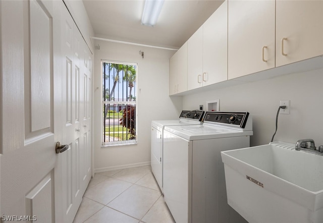 clothes washing area with plenty of natural light, cabinets, sink, and light tile flooring