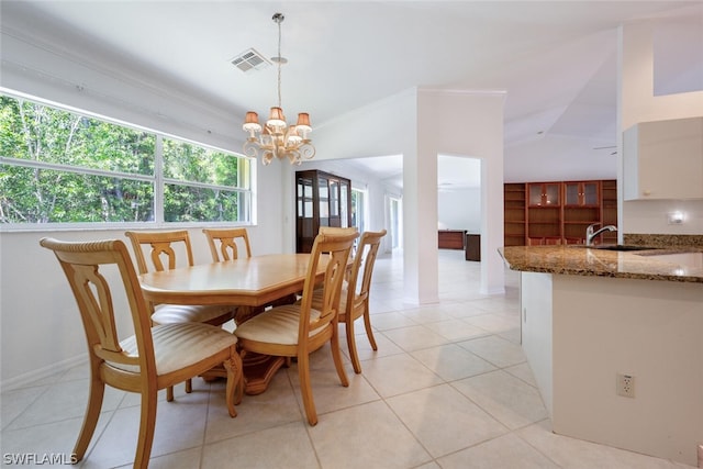 dining space featuring crown molding, a chandelier, lofted ceiling, sink, and light tile floors