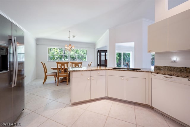 kitchen with kitchen peninsula, stone countertops, crown molding, dishwasher, and stainless steel fridge