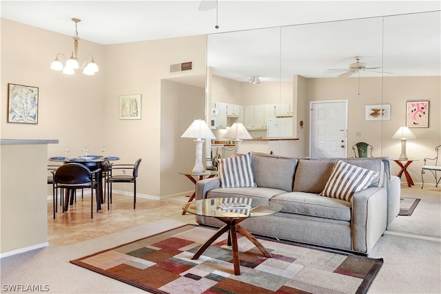 carpeted living room with ceiling fan with notable chandelier