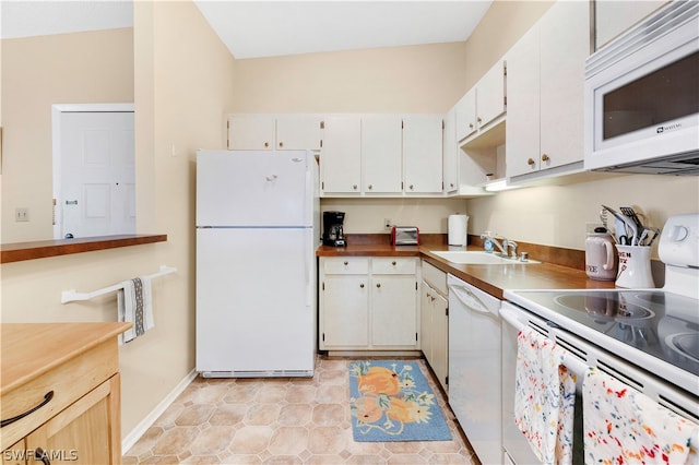 kitchen with lofted ceiling, light tile floors, white appliances, white cabinets, and sink