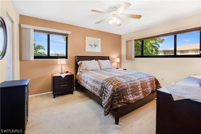 carpeted bedroom with a closet, multiple windows, and ceiling fan