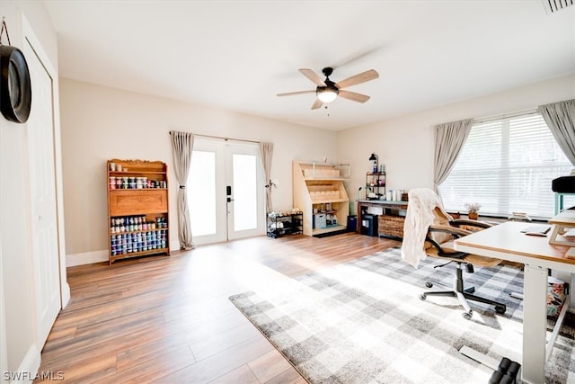 office featuring french doors, ceiling fan, and light hardwood / wood-style flooring