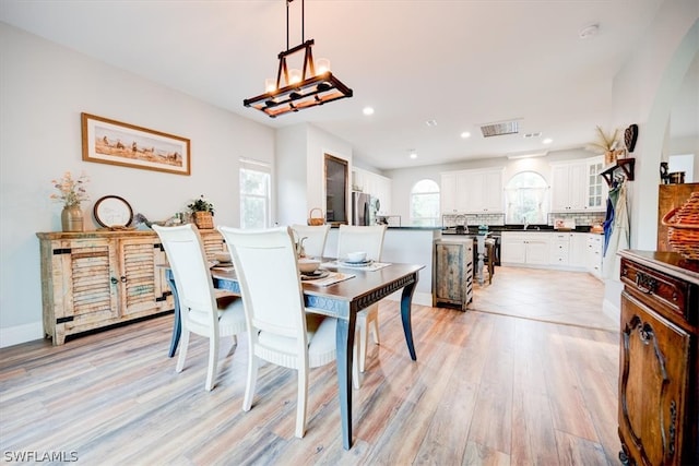 dining space featuring plenty of natural light, an inviting chandelier, and light tile floors