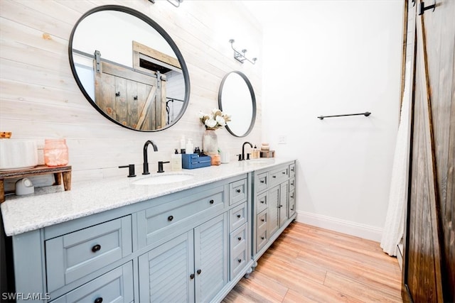 bathroom featuring wooden walls, double vanity, and hardwood / wood-style flooring