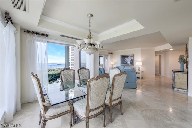 dining space featuring a notable chandelier, a water view, light tile patterned floors, and a tray ceiling