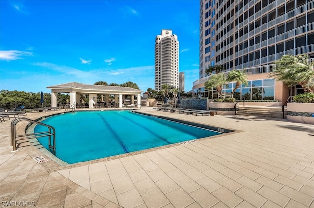 community pool with a gazebo and a patio