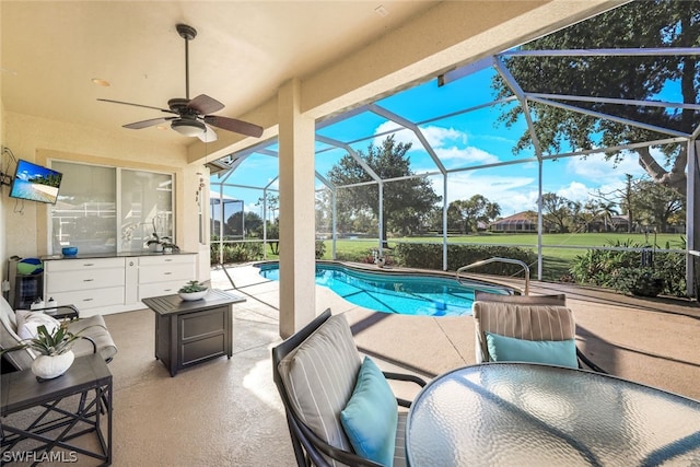 view of pool featuring glass enclosure, ceiling fan, and a patio