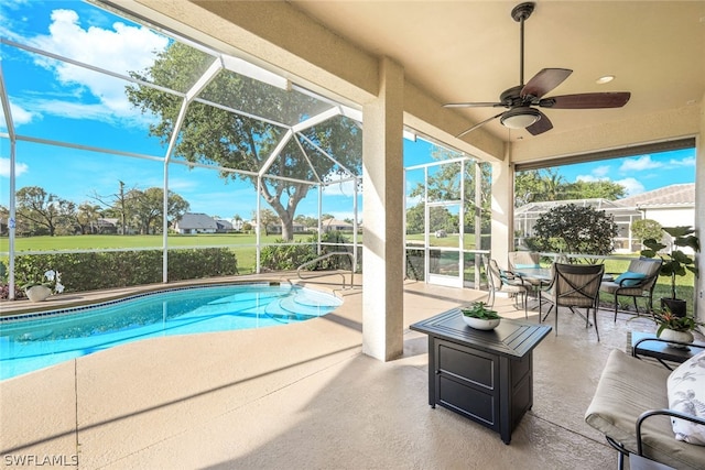 view of pool featuring ceiling fan, a patio, and glass enclosure