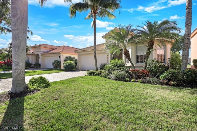 mediterranean / spanish house with a garage and a front lawn