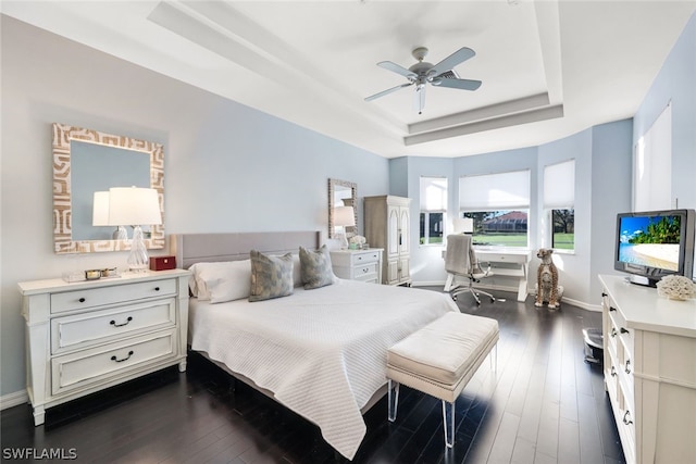 bedroom featuring a raised ceiling, ceiling fan, and dark hardwood / wood-style floors