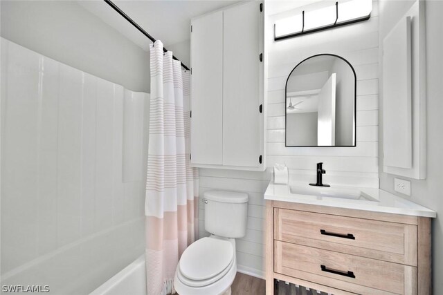 full bathroom with vanity, shower / tub combo, hardwood / wood-style flooring, and toilet