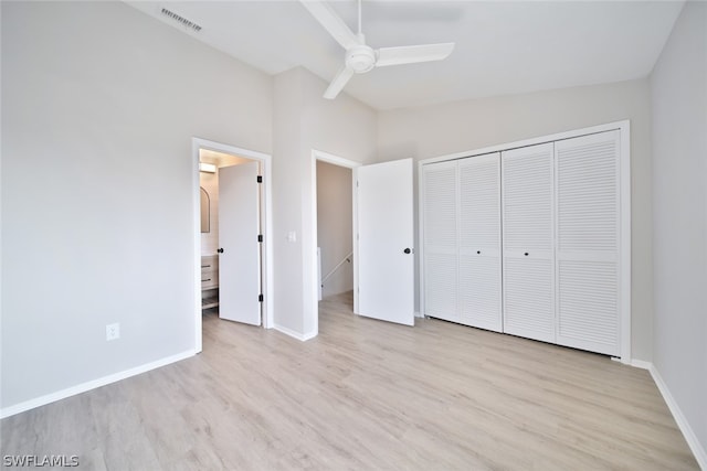 unfurnished bedroom featuring high vaulted ceiling, a closet, light wood-type flooring, and ceiling fan