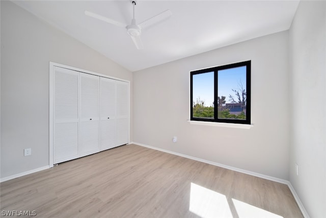 unfurnished bedroom with light hardwood / wood-style flooring, a closet, ceiling fan, and vaulted ceiling