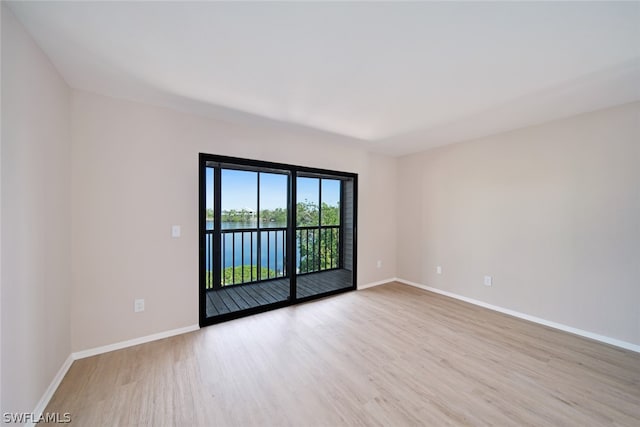 spare room with light hardwood / wood-style flooring and a water view