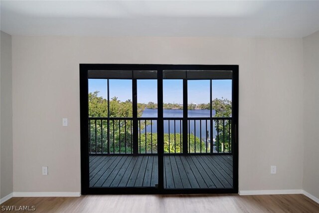 interior space featuring a water view, hardwood / wood-style flooring, and plenty of natural light