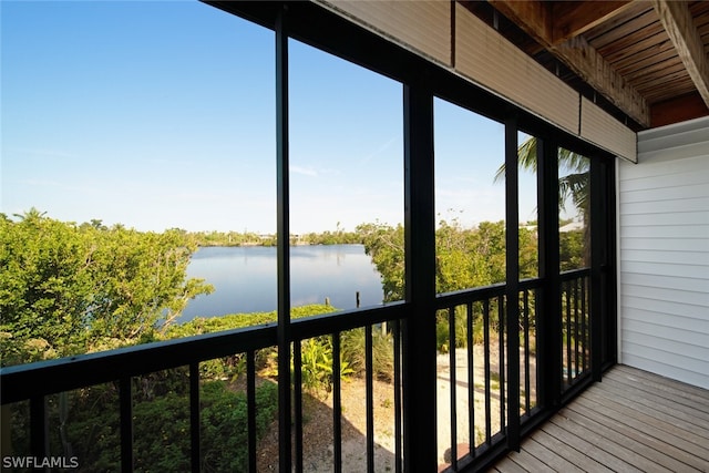 unfurnished sunroom featuring a water view