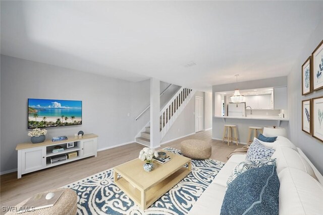 living room with sink and light hardwood / wood-style flooring