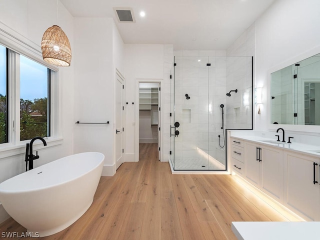 bathroom with vanity, separate shower and tub, and hardwood / wood-style floors