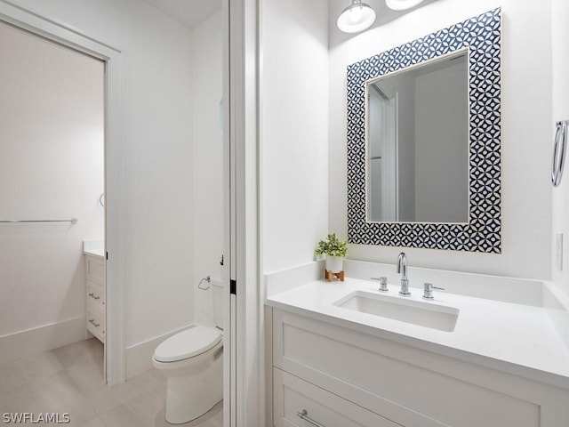 bathroom featuring vanity, tile patterned floors, and toilet