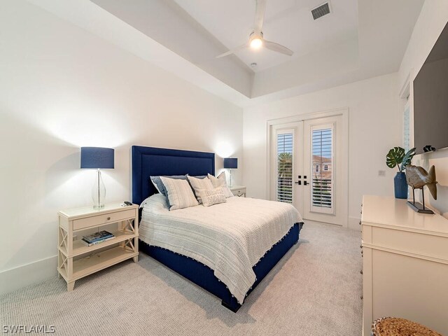 bedroom featuring french doors, light carpet, a raised ceiling, ceiling fan, and access to exterior