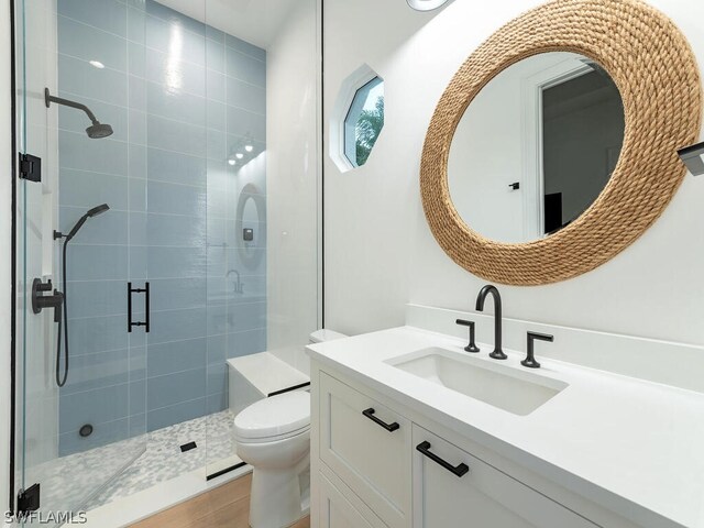 bathroom with vanity, walk in shower, tile patterned floors, and toilet