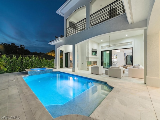 view of pool with a patio area, an outdoor living space with a fireplace, and an in ground hot tub