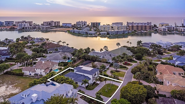 aerial view at dusk featuring a water view