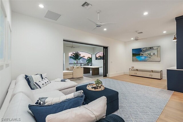 living room featuring wood-type flooring and ceiling fan