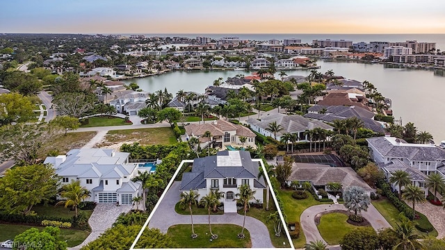 aerial view at dusk featuring a water view