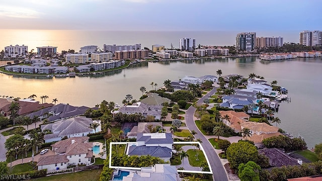 aerial view at dusk featuring a water view