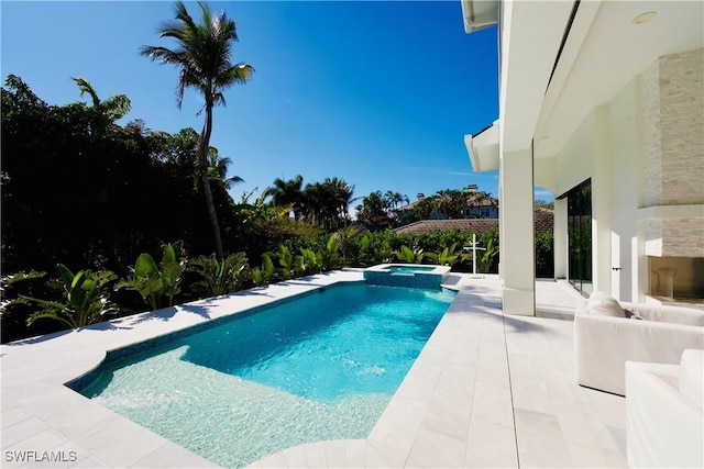 view of swimming pool with an in ground hot tub and a patio