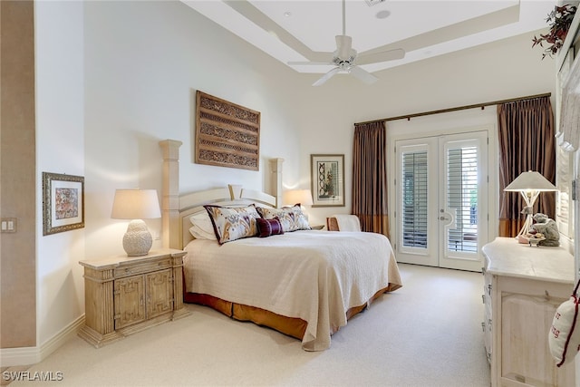 carpeted bedroom with ceiling fan, a raised ceiling, french doors, and access to outside