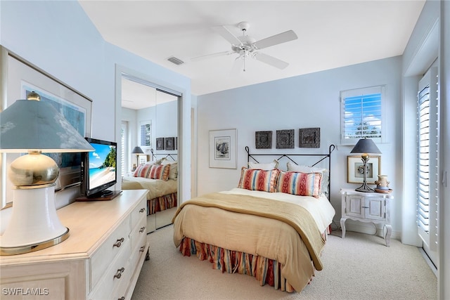 carpeted bedroom featuring a closet and ceiling fan