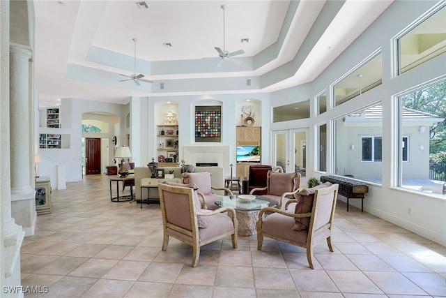 interior space featuring built in shelves, a tray ceiling, and plenty of natural light