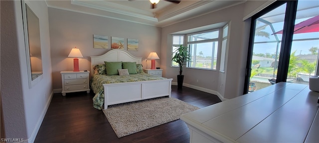 bedroom featuring access to exterior, ceiling fan, crown molding, a tray ceiling, and dark hardwood / wood-style floors