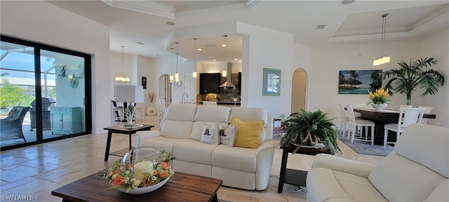 tiled living room with a raised ceiling, a notable chandelier, and sink