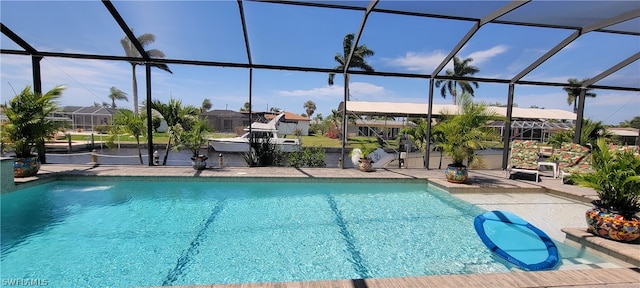 view of pool with glass enclosure and a patio area