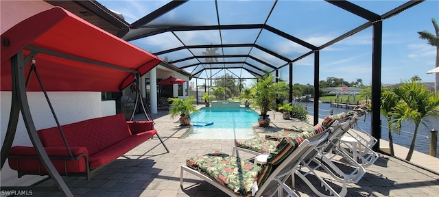 view of pool featuring a patio area, glass enclosure, and a water view