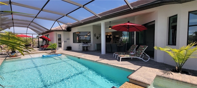 view of pool featuring ceiling fan, a patio area, and a lanai