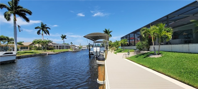 view of dock featuring a lawn, a water view, and a lanai