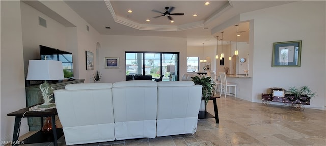 living room featuring a towering ceiling, a tray ceiling, ceiling fan, and light tile flooring