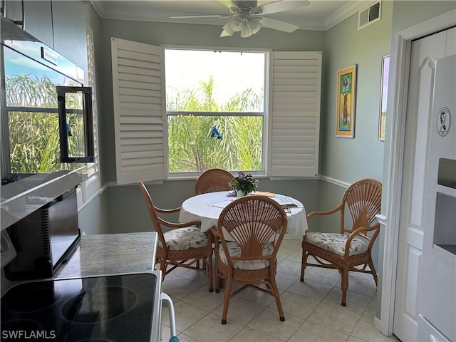 dining space featuring crown molding, light tile flooring, and ceiling fan