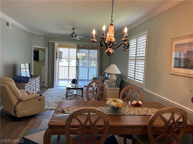 dining space with crown molding, dark hardwood / wood-style floors, and ceiling fan with notable chandelier